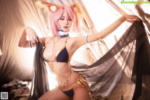 A woman with pink hair is posing for a picture.