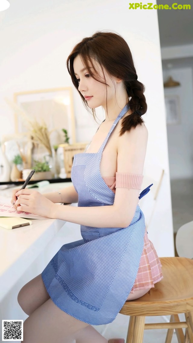 a woman sitting at a table writing on a piece of paper
