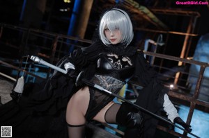 A woman in a black dress holding a sword.