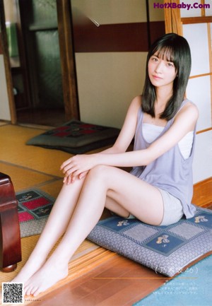 A woman laying on the floor with her legs crossed.