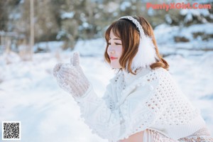 A woman in a white sweater holding a bottle of milk.