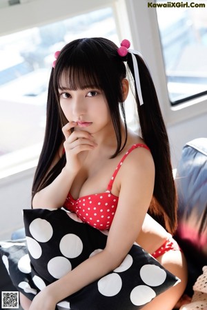 A woman in a red and white polka dot bikini posing for a picture.