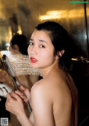 A woman in a red dress sitting in a bathtub.