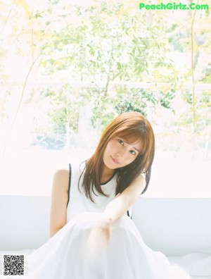 A woman in a white dress posing for a magazine.