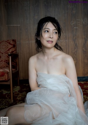 A woman in a white dress standing on a beach.