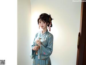 A woman in a blue kimono sitting on a wooden bench.