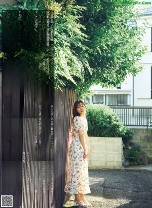 A woman in a white bra and floral skirt posing for a magazine.