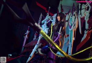 A woman in a purple outfit holding a sword on a stage.