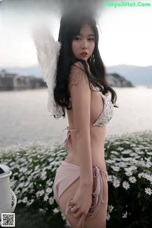 A woman in a pink bikini with white wings.