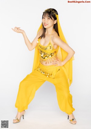 A woman in a purple belly dance outfit posing for a picture.